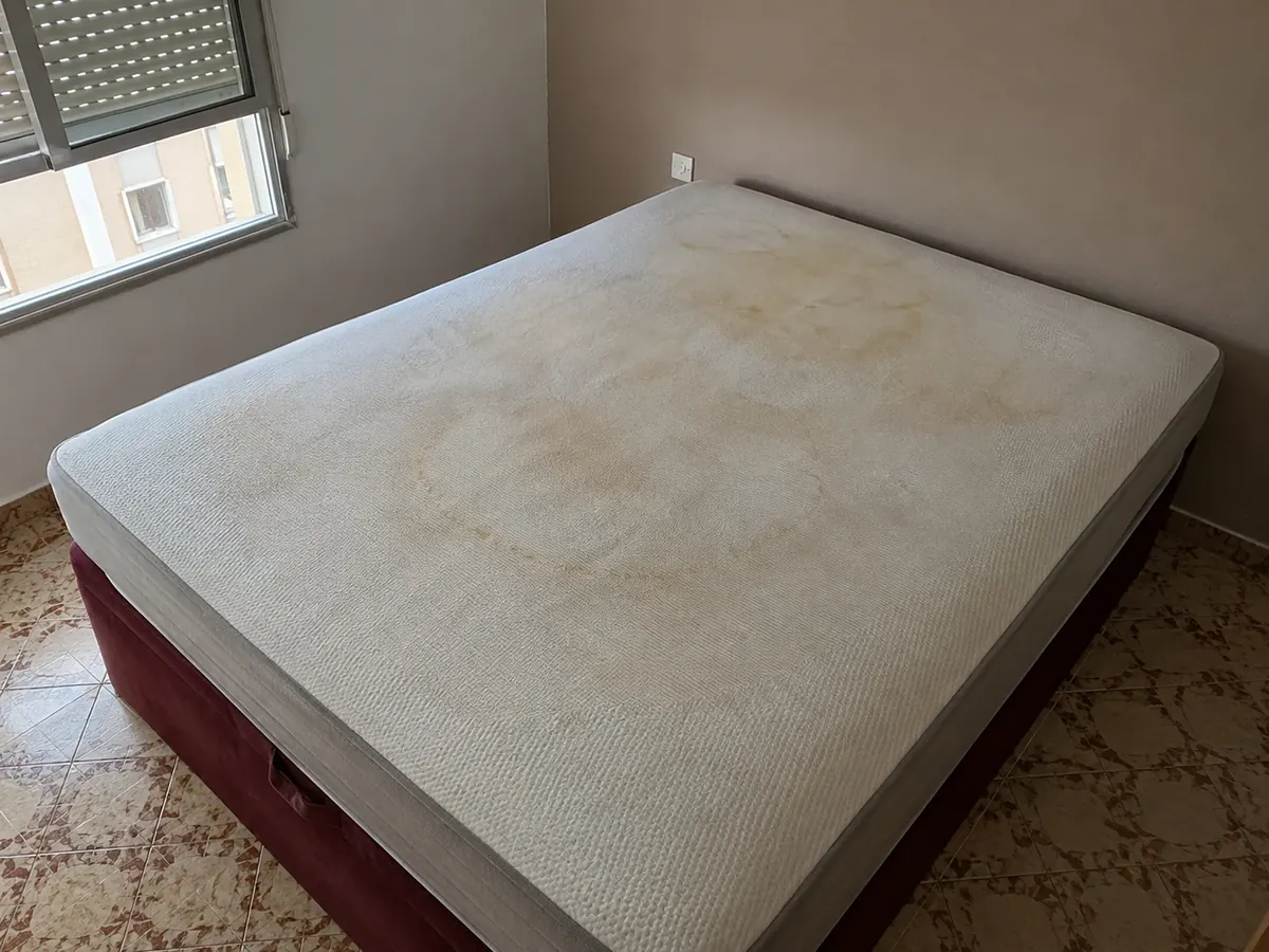 colchón viscoelástico de matrimonio con cercos amarillos de sudor